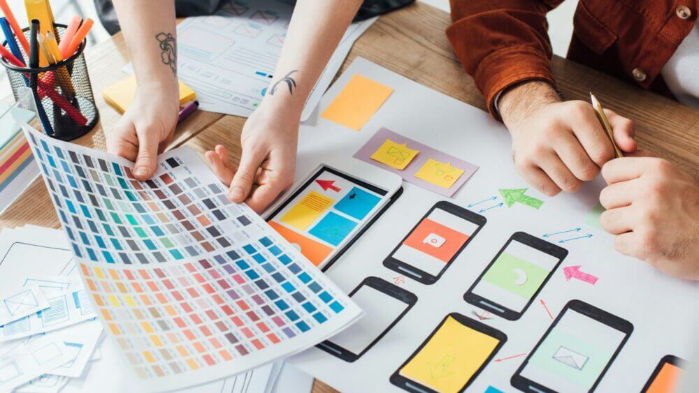 cropped view of designers planning user experience design with color palette and website sketches on 1000x563 - 5 Warning Signs Your Website Desperately Needs a Redesign
